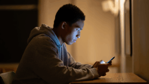Person with tech neck slouching over a smartphone